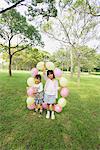 Mädchen posiert mit Luftballons