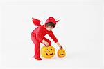 3 Year Boy Dressed Up As Devil with Pumpkins