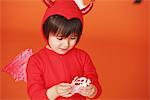 Boy Dressed Up As Devil against Holding Ghost