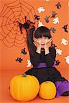 Girl Dressed In Costume for Halloween with Pumpkins