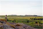 Australia, Northern Territory, Kakadu National Park, Ubirr.  A hiker looks out over the Nadab floodplain at the sacred Aboriginal site of Ubirr.