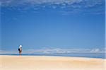 Australia, Tasmania, Strahan.  A hiker looks out over Henty Dunes - a desert-like expanse of coastal sand dunes near Strahan.