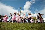 Norfolk, Holt Hall. Children dressed as fairies dance around a maypole at the annual Fairy Fair.