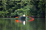 India, Ranganathittu Bird Sanctuary. A man rows across the lake with brightly-painted oars.