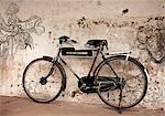 India, Cochin. A bike leans against an artistically-graffitied wall.