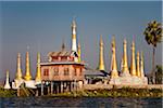 Myanmar, Burma, Lake Inle. A collection of golden stupas, with their 'htis' (umbrella tops) gleaming in the sun, in the middle of Inle Lake.
