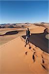 Namibie, Sossusvlei. Un touriste randonnées vers le haut de l'un des célèbres dunes de Sossusvlei.