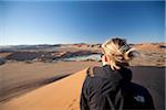 Namibie, Sossusvlei. Un touriste randonnées vers le haut de l'un des célèbres dunes de Sossusvlei.