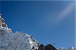 Nepal, Everest Region, Khumbu Valley. A rescue helicopter dwarfed by the surrounding ridges of Mount Everest heads back towards Kathmandu with a casualty of high altitude aboard