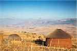 Cabanes de village avec la pointe de la cathédrale en arrière-plan, Ukhahlamba Drakensberg Park, KwaZulu-Natal, Afrique du Sud