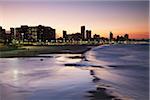 Blick auf die Skyline der Stadt und direkt am Strand bei Sonnenuntergang, Durban, KwaZulu-Natal, Südafrika