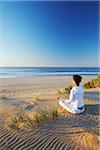 Femme à pratiquer l'yoga sur la plage à l'aube, Bay de Jeffrey, Eastern Cape, Afrique du Sud