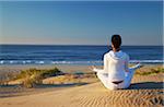 Woman practicing yoga on beach at dawn, Jeffrey's Bay, Eastern Cape, South Africa