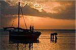 Off-loading cargo from a dhow from Zanzibar at dawn.