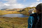 UK, Nordwales, Snowdonia. Mann und Frau, die an den Flanken des Mt Snowdon Wandern.