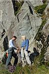 UK, North Wales, Snowdonia.  A man and woman rope up ready to go rock climbing.