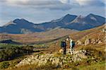 North Wales, Snowdonia.  A man and woman stop to look at their map whilst hiking in Snowdonia.