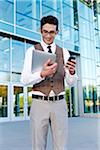 Businessman Holding Cell Phone and Tablet PC