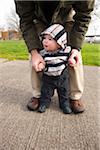 Man Helping Baby Boy to Stand