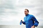 Man running by the sea on cloudy day