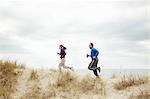 Couple exercising on sand dunes at beach