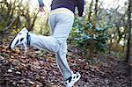 Close up of girls legs running in forest