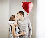 Couple kissing,holding heart balloon