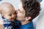 Father kissing baby son on cheek