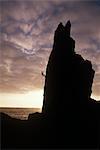 England, Devon, Lundy Island.Climber Abseilen die Nadel in der Abenddämmerung auf der Insel Lundy.Lundy Insel im Bristolkanal, ca. 11 Meilen vor der Küste von North Devon.Three Meilen lang und eine halbe Meile breit liegt, dieser Granit Felsen erhebt sich 400 Meter über dem Meeresspiegel und ist ein Ort von außergewöhnlicher natürlicher Schönheit, mit gewaltigen Blick auf England, Wales und den Atlantik.