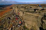 England, Derbyshire, Peak District.Rock climbers at Stanage Edge, Peak District National Park.Situated on the moors north of Hathersage, and visible from miles away down in the Hope Valley, it stretches for a length of approximately six kilometres from its northern tip at Stanage End to the southern point near the Cowper Stone.
