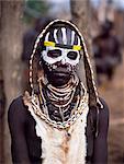 Une femme de Karo avec son visage peint en préparation pour une danse dans le village de Duss. Une petite tribu Omotic associés à Hamar, qui vivent le long des rives du fleuve Omo en Éthiopie le sud-ouest, le Karo sont renommés pour leur peinture sur corps élaborés à l'aide de craie blanche, la pierre concassée et autres pigments naturels. Elle est vêtue d'un tablier de cuir de chèvre et porte une ceinture de cuir décorée de coquillages