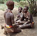 Karo chat de filles à l'ombre de la forêt fluviale qui borde les rives de la rivière Omo. C'est une tradition pour les filles de percer un trou en dessous de la lèvre inférieure dans laquelle ils placent un morceau de métal mince ou un clou pour la décoration.Le Karo sont une tribu vivant dans trois villages principaux le long du cours inférieur du fleuve Omo en Éthiopie.