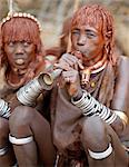 Une femme de Hamar souffle une trompette étain à un saut de la cérémonie du taureau.Le Hamar sont des bergers nomades du sud-ouest de l'Éthiopie dont les femmes portent suppression de style et costumes traditionnels leur mode de mop rouge cheveux ocrées semi.Le saut de la cérémonie de Bull est un rite de passage pour les jeunes hommes.