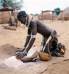 Une femme Nyangatom broie le sorgho à l'aide d'une pierre plate.Le Nyangatom sont une des plus grandes tribus et on peut dire que les gens plus belliqueuses vivant le long de la rivière Omo, au sud-ouest de Ethiopia.They font partie de la Ateger un groupe de sept tribus nilotiques orientales les anglophones dont le Turkana du Kenya du Nord et les Karamajong du nord-est de l'Ouganda font partie.