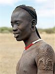 Ein Mursi-Mann mit Skarifizierung in Form einer Krone.Die Mursi sprechen eine nilotische Sprache und Affinitäten mit den Schilluk und Anuak östlichen Sudan haben. Sie leben in einem abgelegenen Gebiet im Südwesten Äthiopiens entlang des Omo-Flusses.