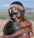 A Samburu woman wearing a mporro necklace, which denotes her married status. These necklaces were once made of hair from giraffe tails but nowadays, the fibres of doum palm fronds, Hyphaene coriacea, are used instead.The red beads after which the necklace is named are wound glass beads made in Venice c.1850.