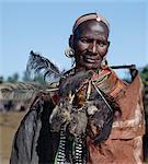 Stolze Mutter von zwei vor kurzem beschnittenen jungen Samburu trägt kurz ihren Vogel Haut Kopfschmuck um ihren Hals, nachdem sie während der Lmuget-Loolbaa-Zeremonie zu verwerfen einen Monat nach ihrer Beschneidung. Sie werden wiederum wegwerfen noch am gleichen Abend und sicherzustellen, dass das Vieh Familys Trampeln sie einziehen damit sie nie verwendet oder wieder in der Öffentlichkeit gesehen.