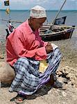 Ein Mann stickt Swahili Hut entlang der Uferpromenade am Kisingitini, einem Naturhafen auf Pate Island.It dauert Stunden Geduld und viel Geschick, einen wirklich feinen Hut, beenden die Muslime während des Lamu-Archipels und anderswo geschätzt werden wird.