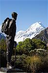 New Zealand, South Island, Mackenzie Country.Mt Cook National Park, a statue of Sir Edmund Hillary stands infront of the Hermitage Hotel and Mount Cook, 3755m, the highest peak in New Zealand and part of Te Wahipounamu World Heritage Site.