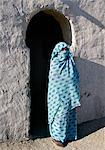 Une femme Nubienne, son visage couvert par son foulard pour désigner sa croyance musulmane, se trouve à l'extérieur de la véranda de sa maison.Le style de l'arc de la véranda est typique du peuple nubien.