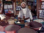 A Yemeni trader at his market stall in the old Suq.The suq or central market is located in a labyrinth of streets and alleyways in the centre of the old city. A large variety of merchandise is offered for sale yet sectors specialising in specific commodities make shopping comparatively easy.