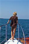 boy standing on bow of yacht