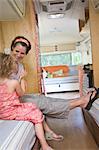 woman and girl seated inside camper