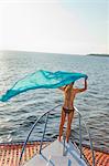 woman on bow of yacht with flying sari