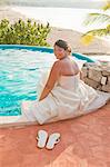bride sitting with feet in pool
