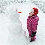 A girl and a snowman looking at eachother, Sweden.