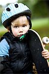 Portriat of a small boy holding a skateboard, Sweden.