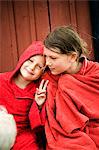 Zwei skandinavische Mädchen sitzen mit ihren Handtüchern umwickelt selbst, Öland, Schweden.