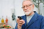 Un vieil homme à l'aide d'un téléphone cellulaire.