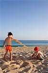 Kinder spielen am Strand.